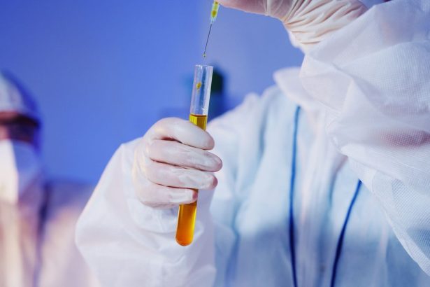 Cientista usando equipamento de proteção realiza um teste com tubo de ensaio em laboratório.