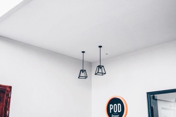Interior minimalista de um espaço modular com luminárias geométricas e uma placa com a palavra “POD”.